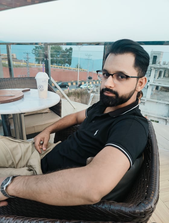 Farrukh on a rooftop café in Islamabad, mountains behind him